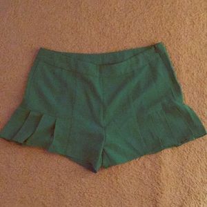 Emerald green high waisted shorts with ruffles.